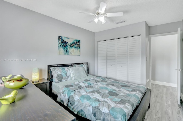 bedroom featuring a closet, ceiling fan, baseboards, and wood finished floors