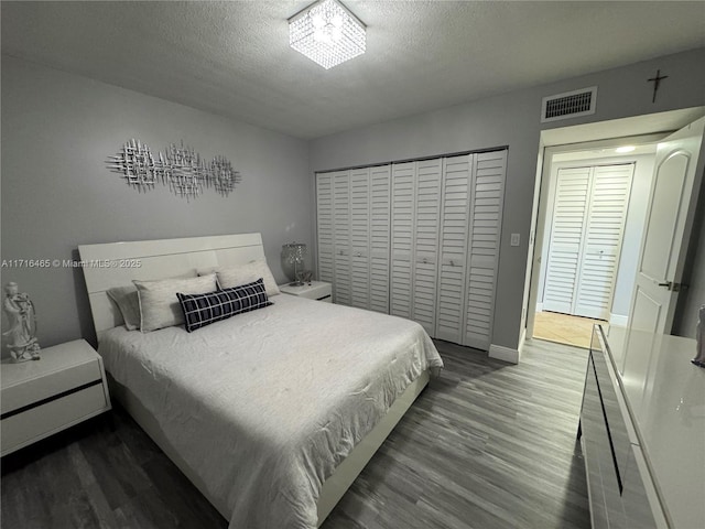 bedroom with hardwood / wood-style floors, a textured ceiling, and a closet