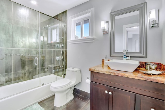 bathroom featuring vanity, toilet, and bath / shower combo with glass door