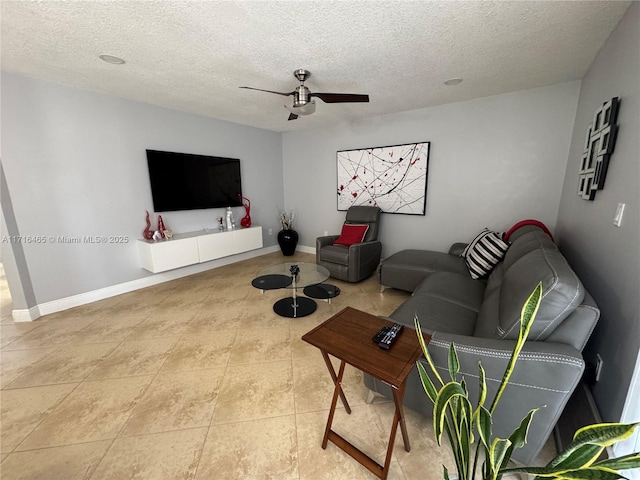 living room with ceiling fan, tile patterned flooring, and a textured ceiling