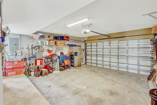 garage featuring electric panel, a garage door opener, and stainless steel fridge