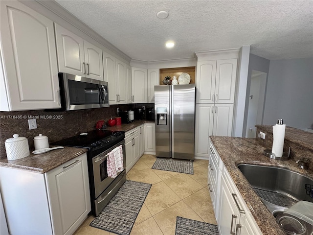 kitchen with white cabinets, a textured ceiling, and appliances with stainless steel finishes