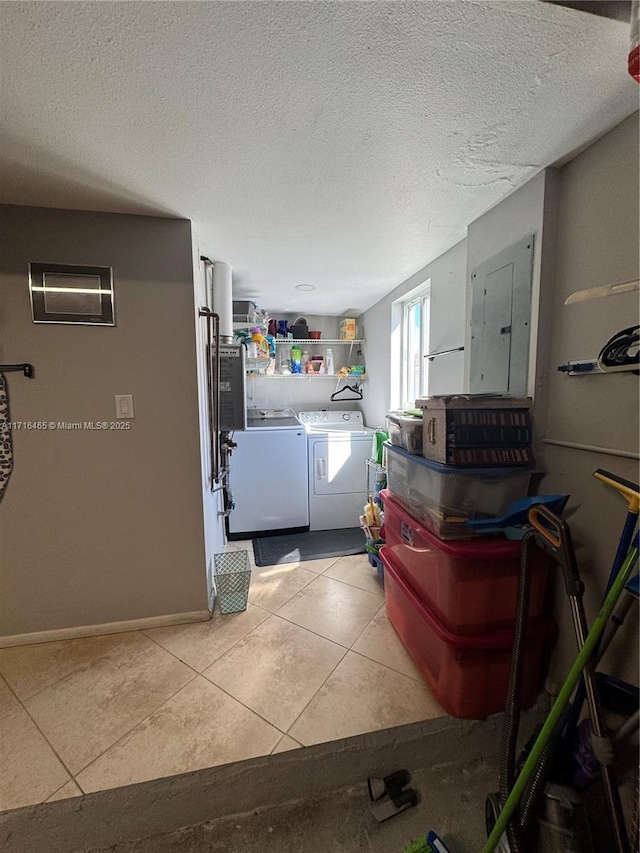 washroom with washer and dryer, light tile patterned floors, a textured ceiling, and electric panel