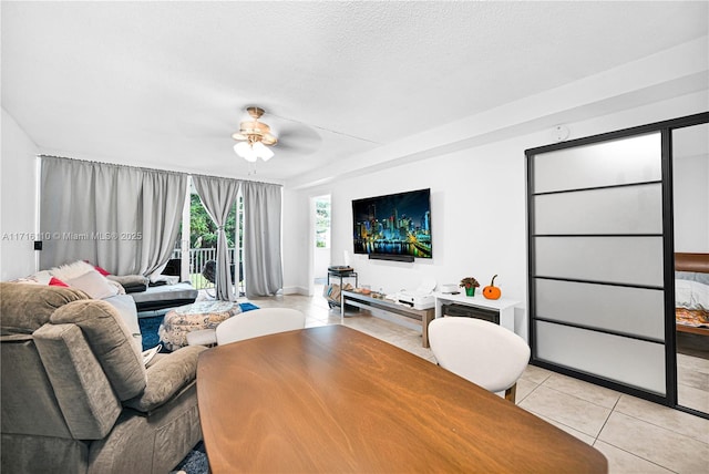 tiled living room with ceiling fan and a textured ceiling