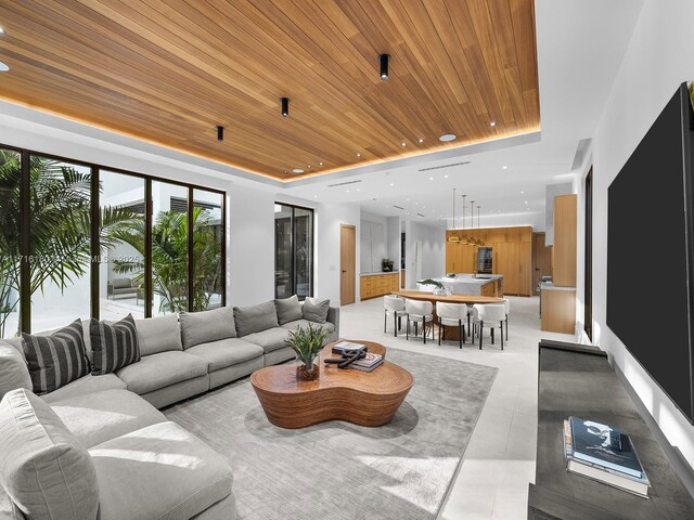 living room featuring wood ceiling, a tray ceiling, and recessed lighting