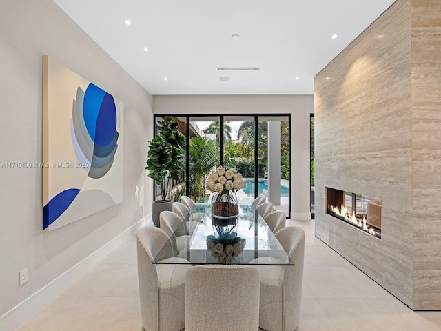 interior space with recessed lighting, light tile patterned flooring, baseboards, and a multi sided fireplace