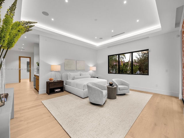 bedroom featuring visible vents, baseboards, a raised ceiling, light wood-type flooring, and recessed lighting