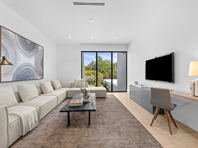 living area with recessed lighting, visible vents, and light wood finished floors