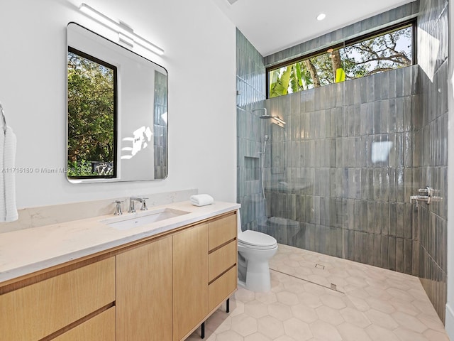 bathroom featuring tile patterned flooring, vanity, toilet, and walk in shower