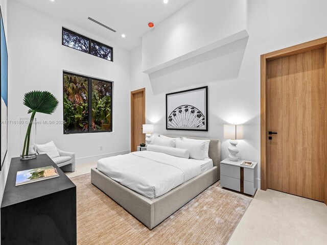 bedroom with a high ceiling and recessed lighting