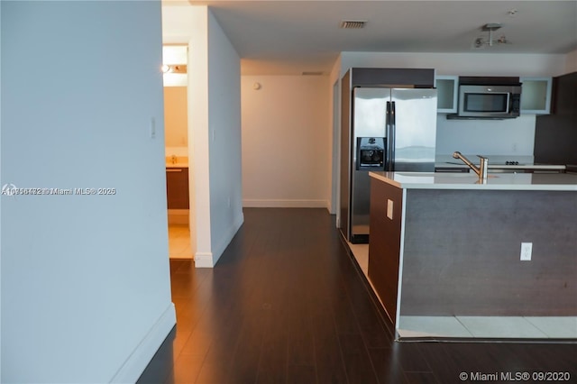 kitchen with appliances with stainless steel finishes, dark wood-type flooring, and sink