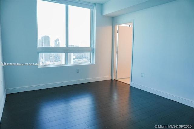 empty room with dark hardwood / wood-style flooring