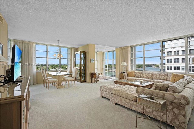 carpeted living room with a chandelier and a textured ceiling