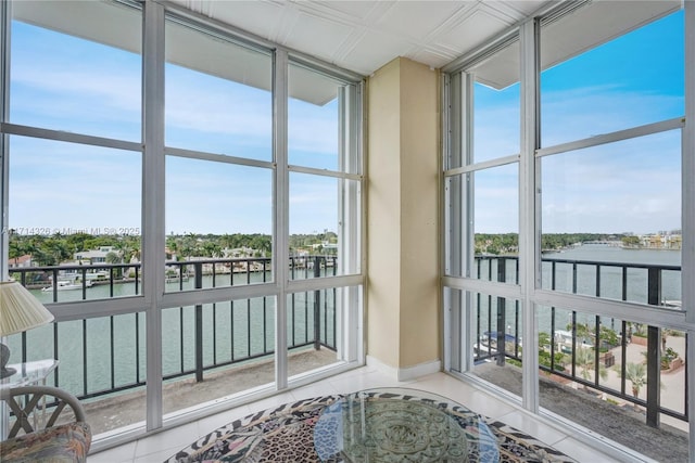 sunroom featuring a water view