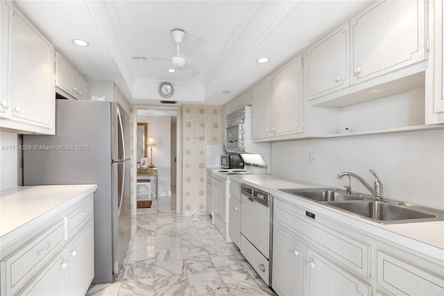 kitchen featuring white cabinetry, sink, stainless steel appliances, and a raised ceiling