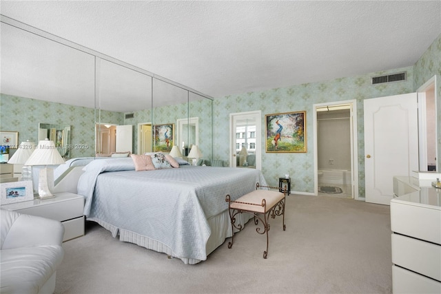 bedroom with light carpet and a textured ceiling