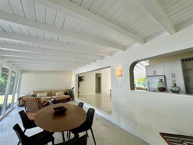 dining space featuring beamed ceiling