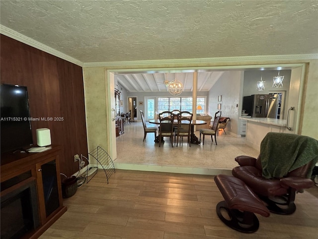 dining room featuring a chandelier, wood-type flooring, and a textured ceiling