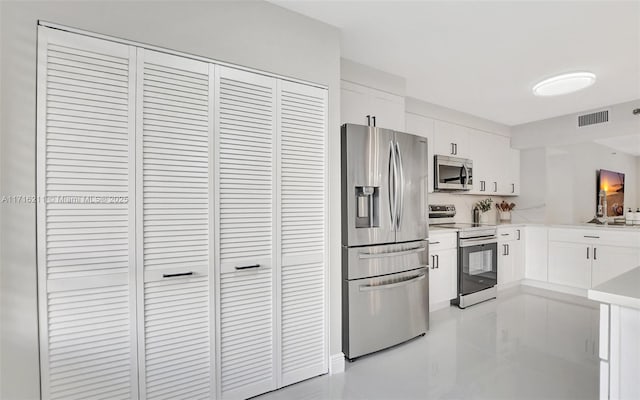 kitchen with light tile patterned floors, white cabinetry, and appliances with stainless steel finishes