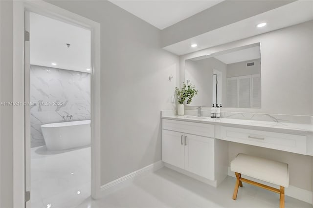 bathroom with a tub, vanity, and tile walls