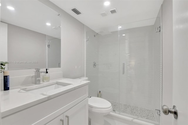 bathroom featuring a shower with door, vanity, and toilet