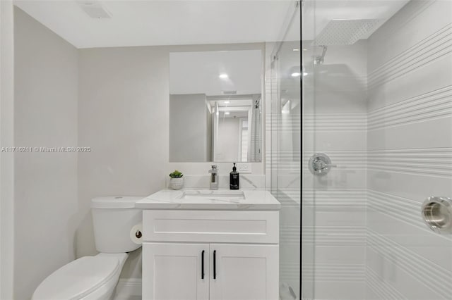 bathroom with walk in shower, vanity, and toilet