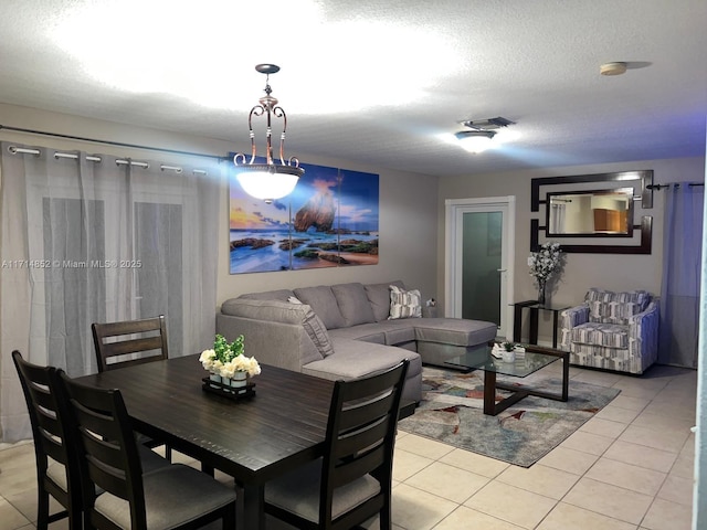 tiled dining space featuring a textured ceiling