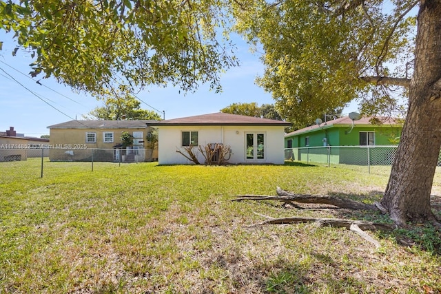 back of property featuring a yard, a fenced backyard, french doors, and stucco siding