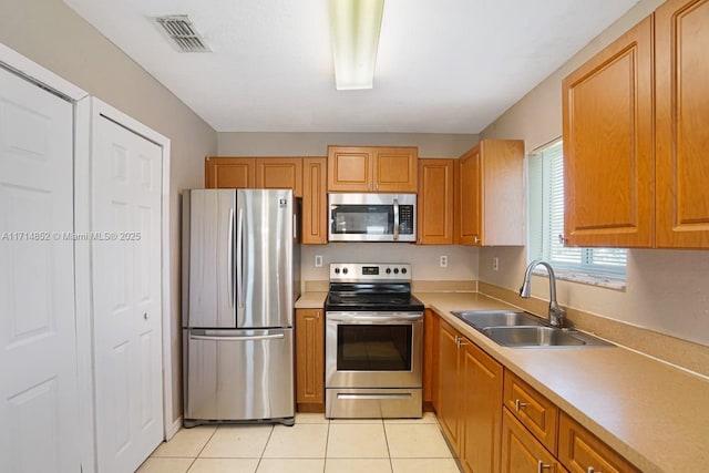 kitchen with visible vents, light countertops, light tile patterned floors, appliances with stainless steel finishes, and a sink