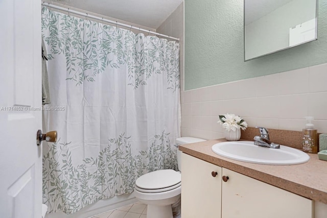 full bath with a shower with curtain, tile walls, toilet, and vanity