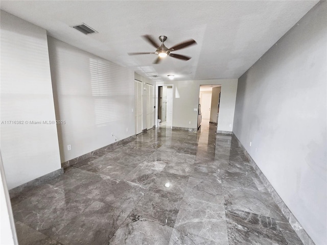 unfurnished room featuring ceiling fan and a textured ceiling