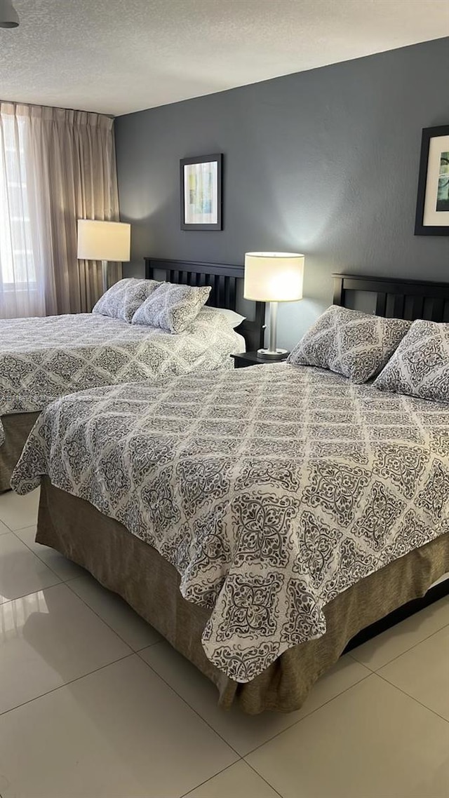 bedroom featuring tile patterned flooring and a textured ceiling