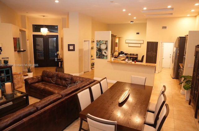 tiled dining space with french doors and a towering ceiling