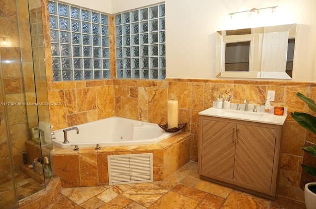 bathroom featuring vanity, tile walls, and independent shower and bath