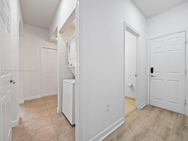 hall featuring light tile patterned flooring and baseboards