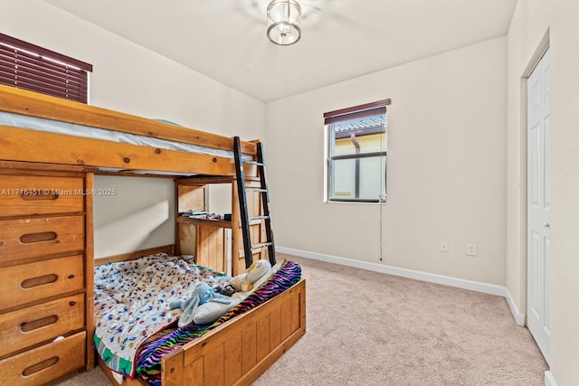 bedroom with light carpet and baseboards