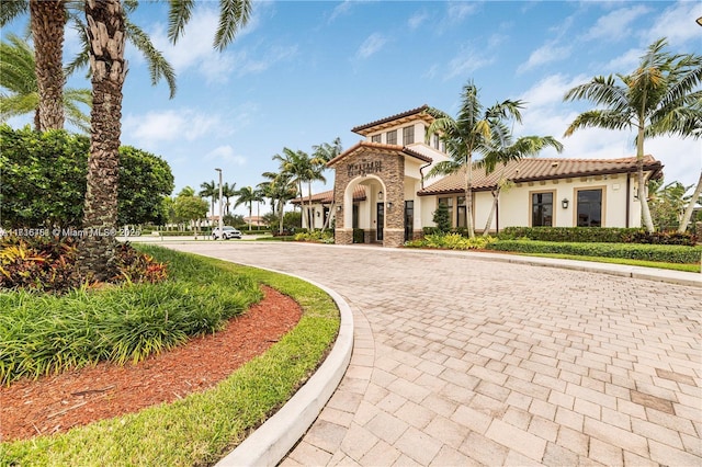 mediterranean / spanish home featuring a tile roof and stucco siding