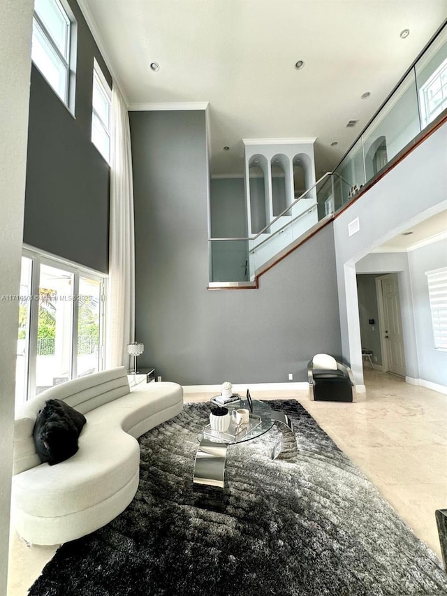 living room with a high ceiling and crown molding