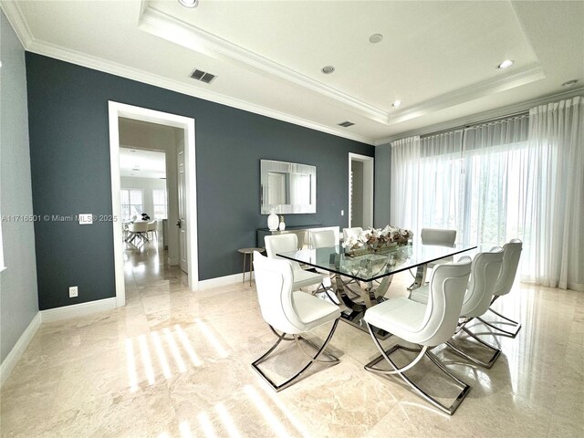 dining area featuring ornamental molding and a raised ceiling