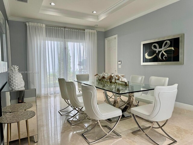 dining space featuring ornamental molding and a tray ceiling