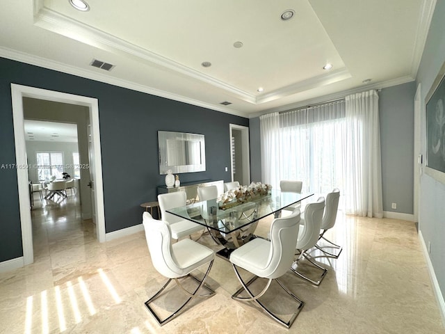 dining space featuring a raised ceiling and crown molding