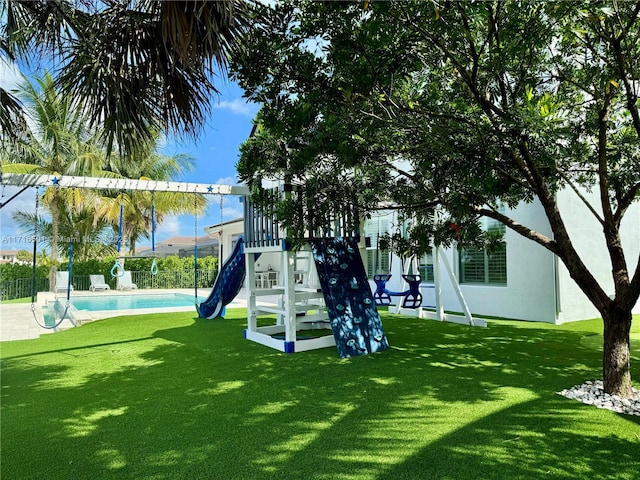 view of jungle gym featuring a yard and a fenced in pool