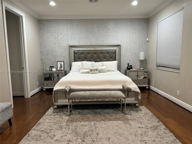 bedroom with crown molding and dark hardwood / wood-style floors