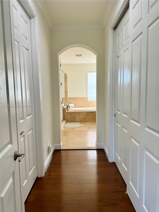 corridor with crown molding and dark wood-type flooring