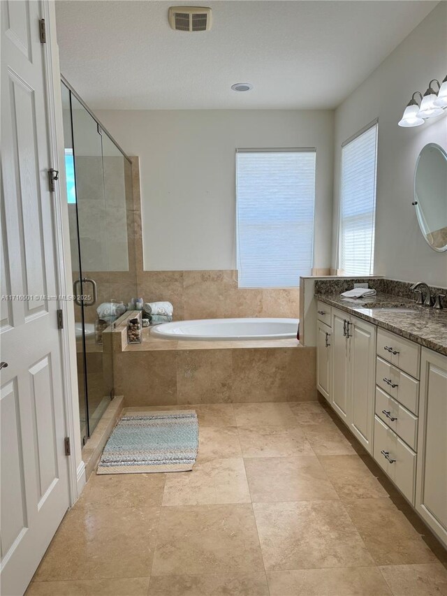 bathroom with vanity and shower with separate bathtub