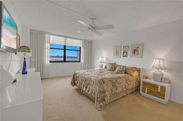 18151 NE 31st Ct Unit 1709, Aventura, FL 33160 - bedroom featuring light colored carpet, baseboards, a textured ceiling, and ceiling fan