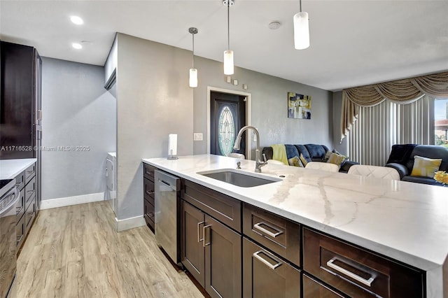 kitchen with light stone countertops, dishwasher, sink, and pendant lighting