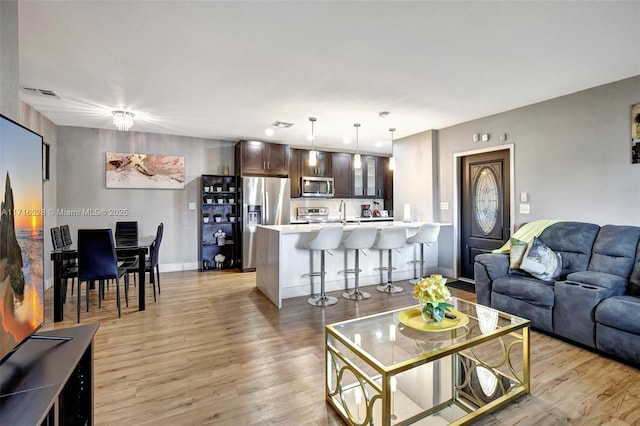 living room with light wood-type flooring and sink