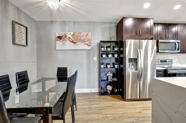 dining space featuring an inviting chandelier and light hardwood / wood-style flooring