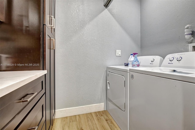 laundry room with light wood-type flooring and washing machine and dryer